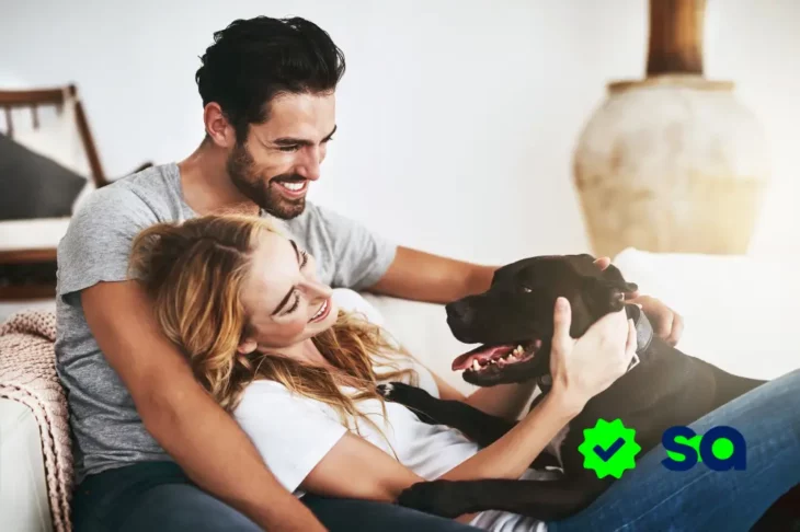 Pareja en casa con su perro reflexionando sobre cuánto gastamos en el bienestar del hogar