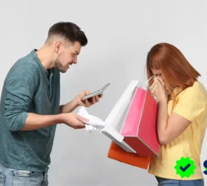 Hombre molesto revisando un recibo mientras confronta a una mujer con varias bolsas de compras, representando el acto de gastar para llenar vacíos emocionales.