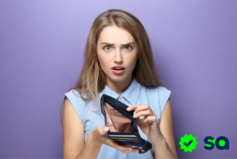 Mujer sorprendida mirando su cartera vacía, representando el impacto negativo de la comparación en las finanzas personales.