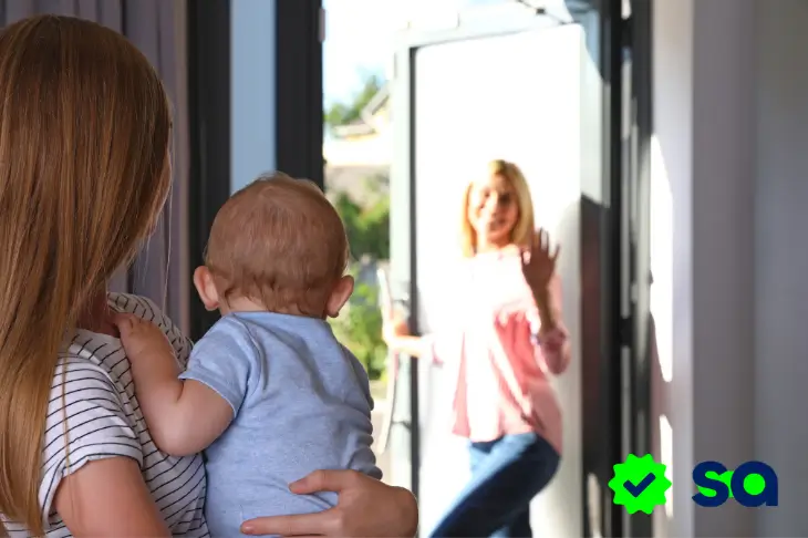 Madre con bebé recibiendo a su au pair en la puerta de casa