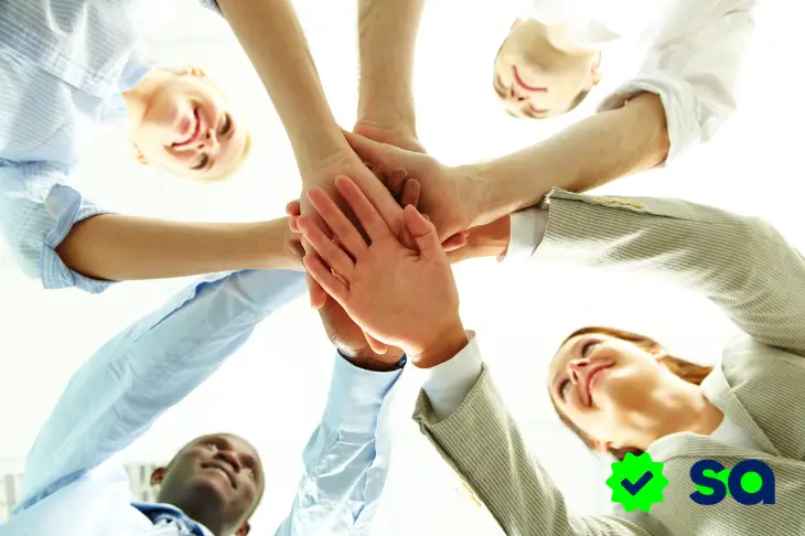 Personas uniendo sus manos en círculo representando la unión en las tandas