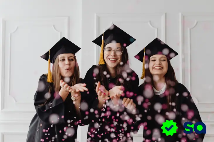 Tres estudiantes celebrando su graduación con birretes, simbolizando la importancia de elegir entre préstamos educativos vs becas.