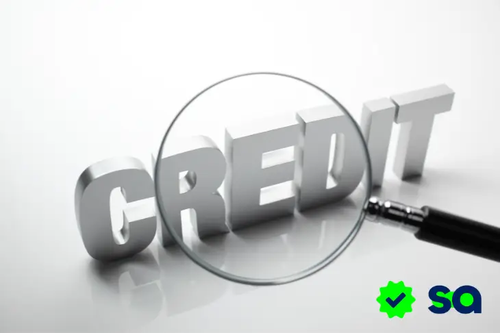 Lupa enfocando la palabra credit en referencia a la revisión del historial en Buró de crédito y círculo de crédito.