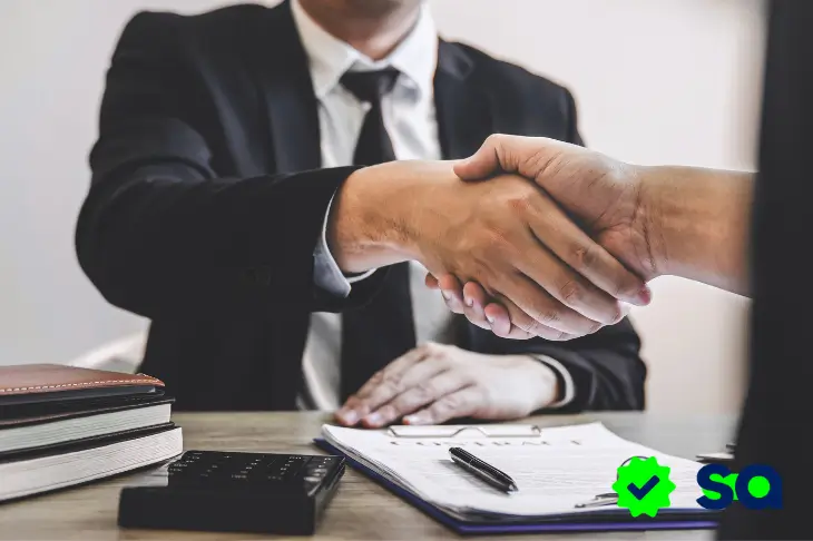 Apretón de manos entre cliente y asesor financiero al cerrar un acuerdo de crédito confiable.