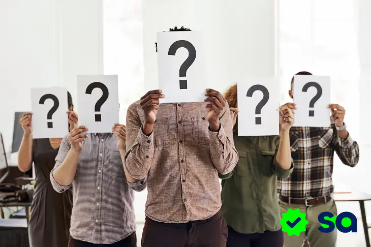 Personas sosteniendo signos de interrogación que representan la duda sobre qué es un aval